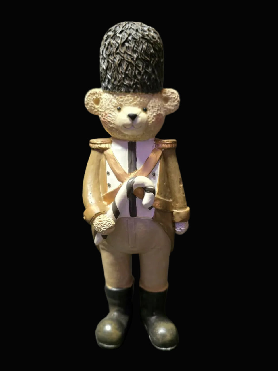 Teddy bear figurine dressed in a military uniform with a tall hat on a dark background