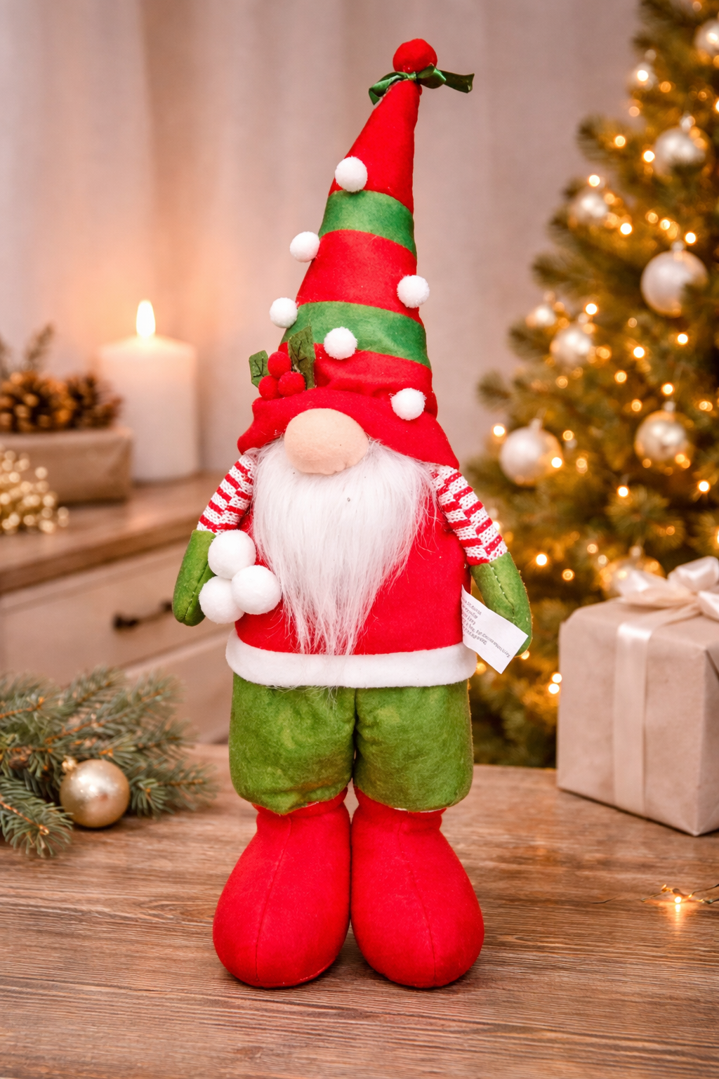  Standing Christmas gnome decoration in red and green with tall striped pom pom hat, holly detail, fluffy white beard, candy-striped sleeves and red boots, styled on a timber surface with a Christmas tree, candle and wrapped gifts — Mistletoe Home