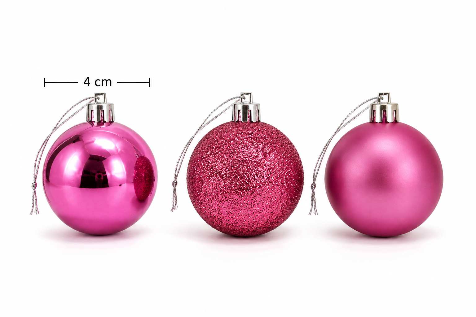 Three 4cm Christmas baubles side by side showing glossy pink, glitter pink and matte pink finishes with size measurement