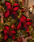 Buffalo plaid poinsettia Christmas tree picks clipped onto a lit Christmas tree with pinecones and ribbon