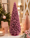 Pink beaded cone Christmas tree displayed on a mantel beside a pink ceramic house, candle, and bottle brush trees