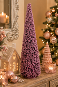 Pink beaded cone Christmas tree displayed on a sideboard beside a lit gingerbread house, candles, and a decorated Christmas tree