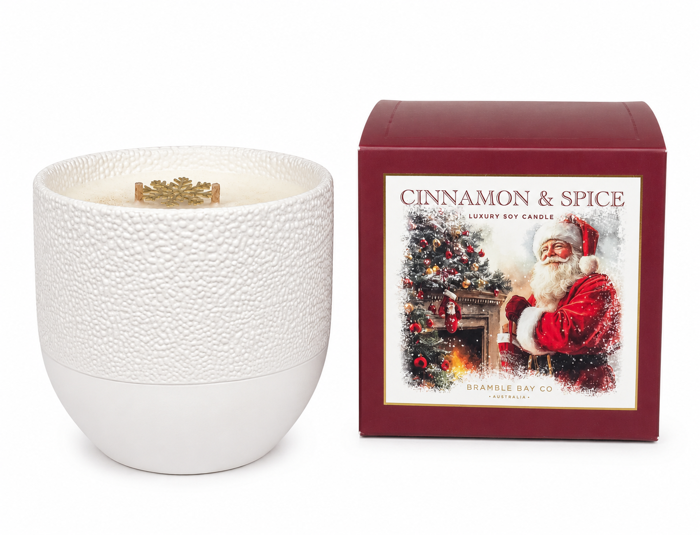 Cinnamon & Spice luxury soy candle in a white textured ceramic vessel next to its burgundy gift box featuring a Bramble Bay Co Santa illustration