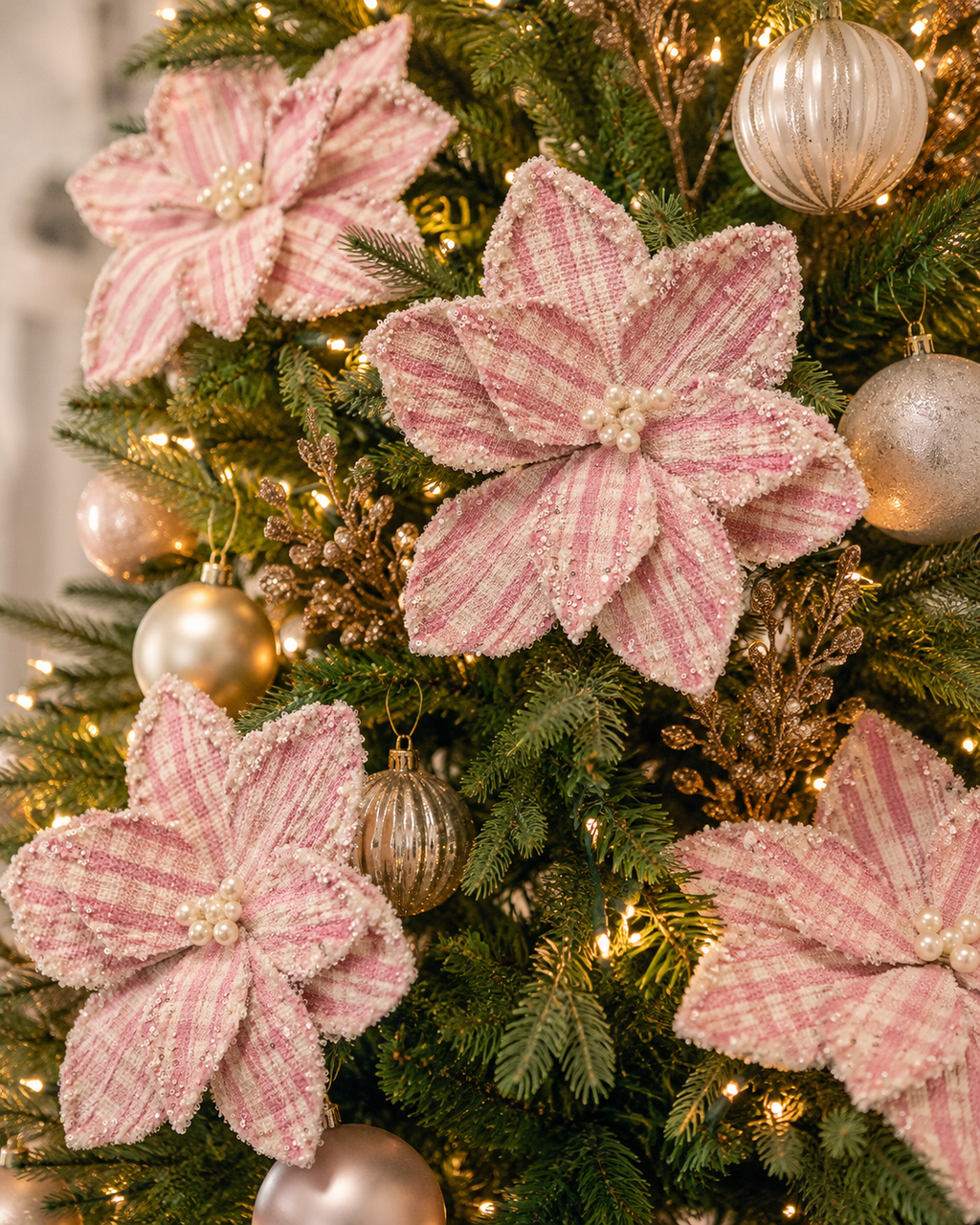 Lilac Chequer Poinsettia stems on a decorated Christmas tree, pink and cream beaded petals nestled among gold ornaments and fairy lights
