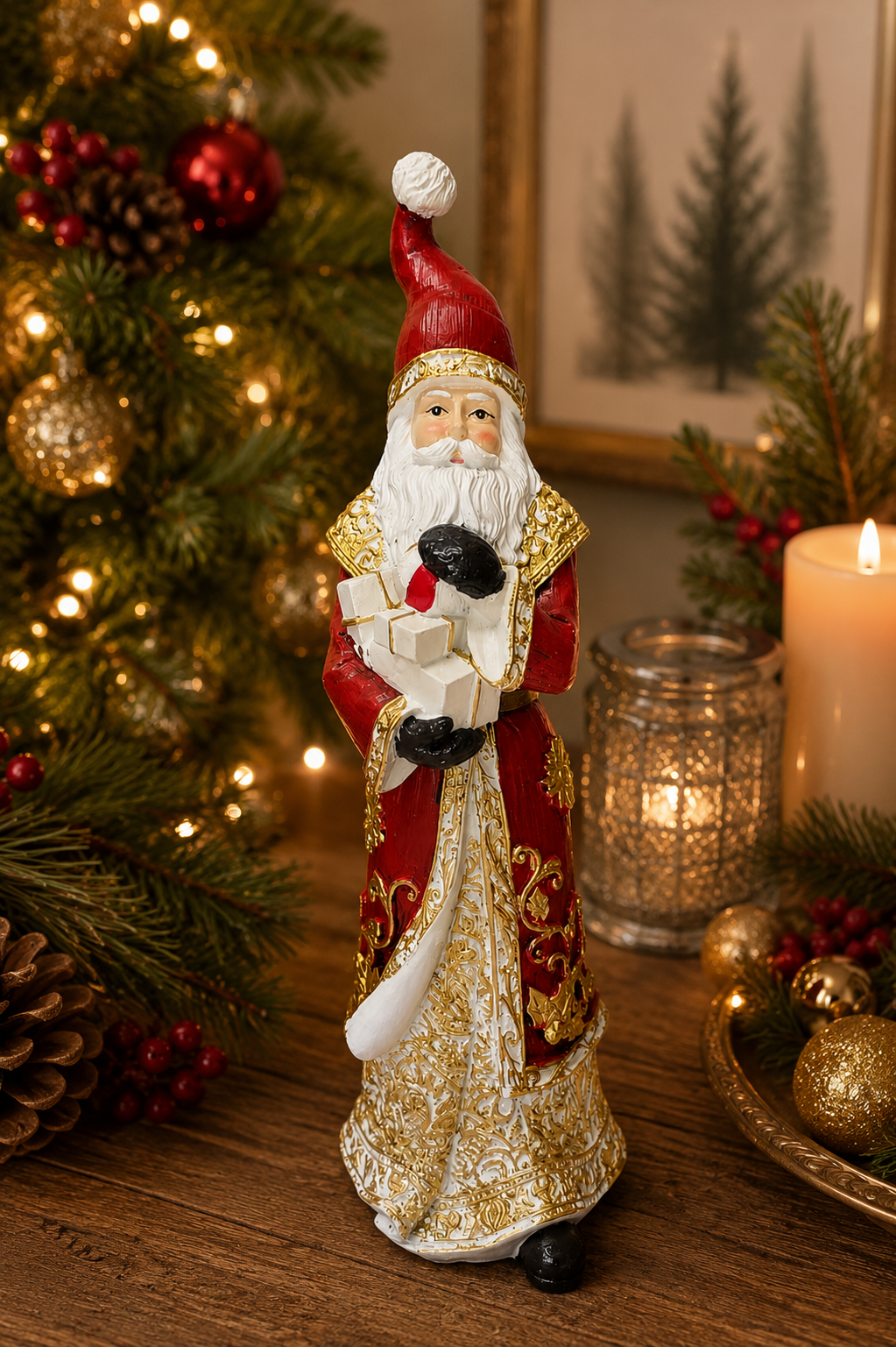 Traditional Santa figurine with presents displayed on a wooden table beside a lit candle and lantern, red robe with gold filigree and stack of white gift boxes visible, Christmas tree in background.