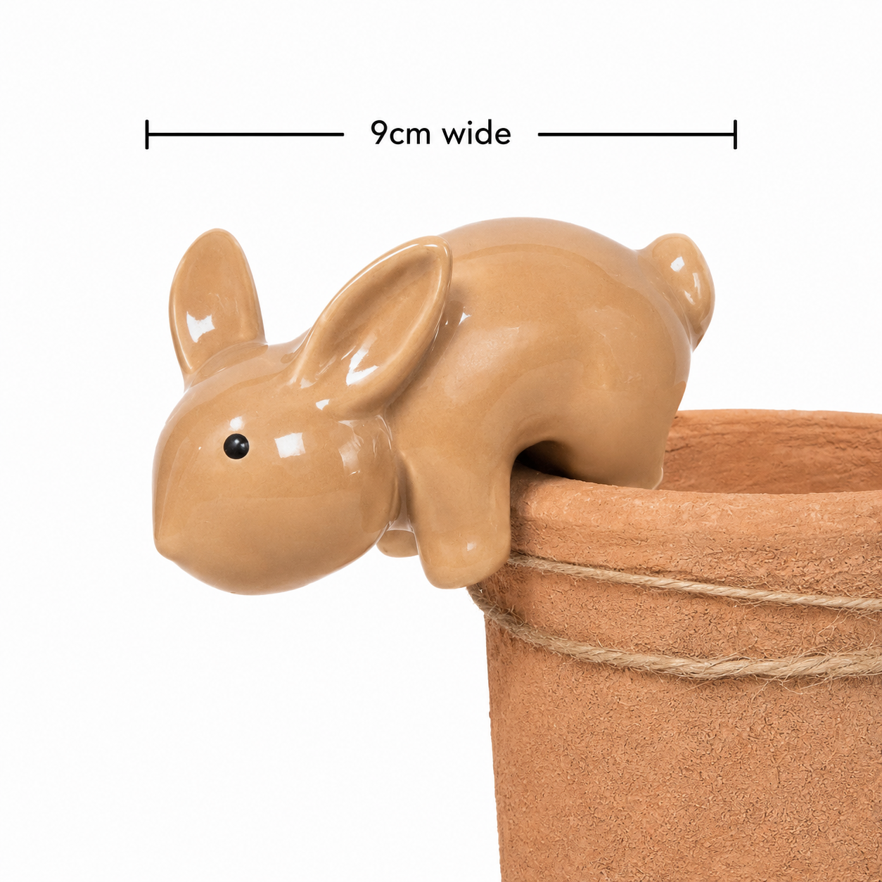 Ceramic bunny pot hanger shown hooked over a terracotta pot edge on white background, 9cm wide.