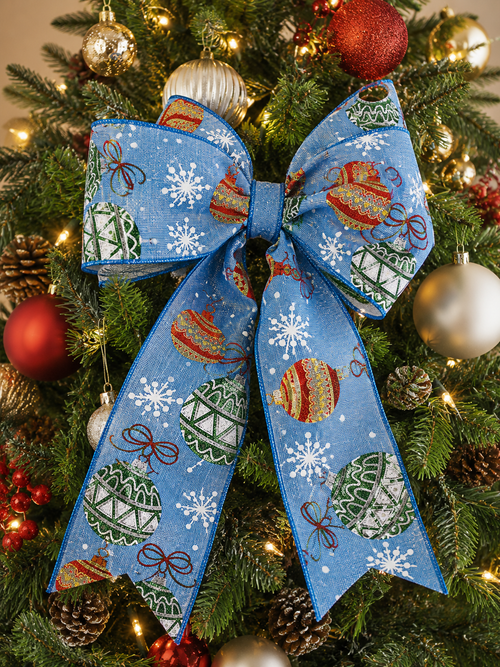 Blue bauble print wired ribbon tied into a bow on a Christmas tree among gold and red baubles