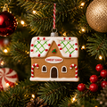 Gingerbread Sweet Shop Hanging Ornament on a decorated Christmas tree with warm fairy lights, red baubles and pine cones
