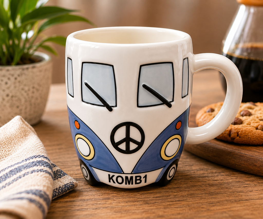 Blue Kombi van ceramic mug filled with black coffee, styled on a wooden table with a plant, candle and books in a cosy home setting