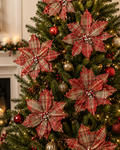 Tartan plaid poinsettia picks decorating a Christmas tree with red and gold baubles and warm fairy lights
