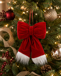 Red velvet Christmas bow with white fur trim hanging on a decorated Christmas tree — Mistletoe Home Australia