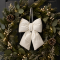 Cream velvet Christmas bow with subtle textural detail hanging on a Christmas wreath with eucalyptus and pinecones — Mistletoe Home Australia