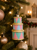 Stacked drums Christmas ornament hanging on decorated tree — pastel pink, mint and blue harlequin pattern with gold drum rim detail