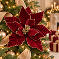 Burgundy velvet poinsettia with gold glitter edges and golden berry centre on a Christmas tree with gold baubles, champagne ribbon and fairy lights