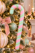 Pink and mint glitter candy cane ornament with gold tinsel stripes hanging on a pastel-themed Christmas tree, surrounded by matching pink and mint baubles and a pink velvet bow