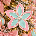 Pink and mint glitter poinsettia flower stem with white pompom trim nestled in a pastel Christmas tree, surrounded by pink velvet bows and warm fairy lights