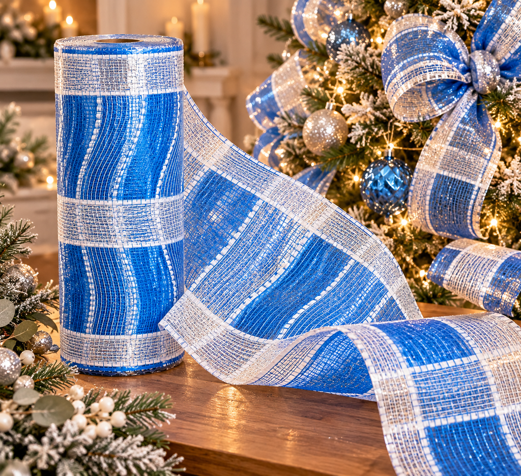 Roll of wide blue and silver plaid mesh ribbon standing upright with a length unrolled across a wooden table near a decorated tree