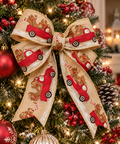 Gingerbread truck Christmas ribbon tied into a large bow on a decorated tree with red baubles and berries