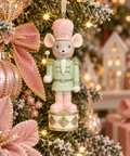 Mint green and pink toy soldier mouse Christmas ornament hanging on a decorated tree with pink ribbons and gold baubles
