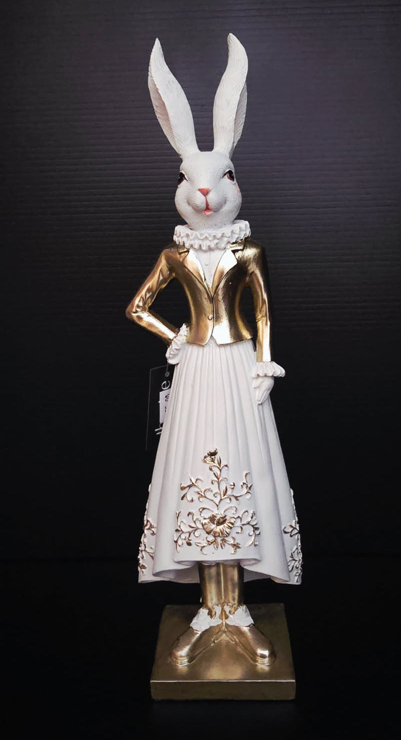 Statue of a rabbit in a gold and white outfit on a black background