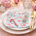 Christmas candy cane paper napkin styled on a white plate with gold cutlery and festive decorations on a pink Christmas table setting — Mistletoe Home Australia