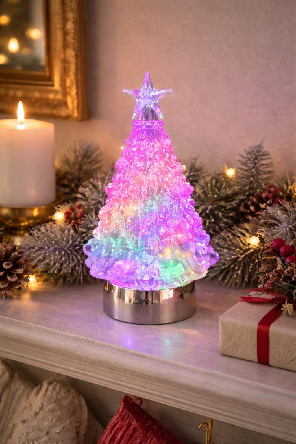 Colour-changing LED acrylic Christmas tree glowing pink and purple on a white mantle styled with frosted garland, pine cones and wrapped gifts — Mistletoe Home