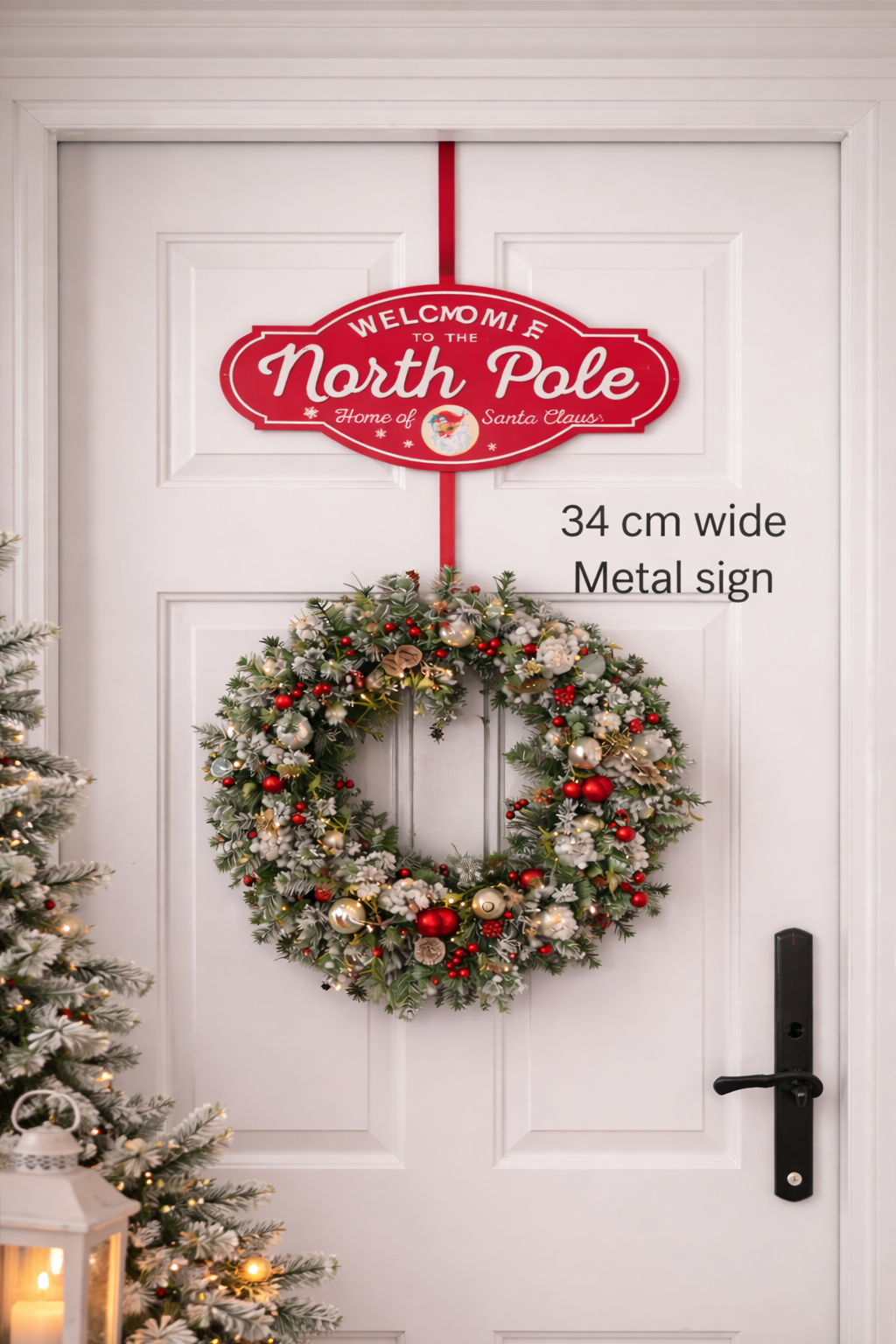Welcome to the North Pole red metal Christmas sign hung on a white front door above a Christmas wreath — Christmas door décor Australia Mistletoe Home