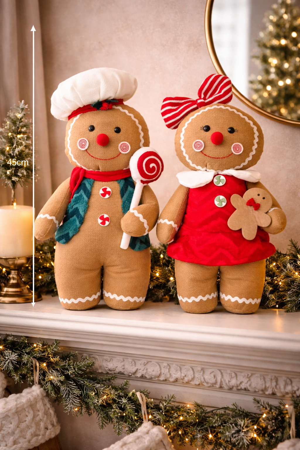 Two oversized 45cm plush gingerbread kid decorations — boy in chef's hat with lollipop and girl in red dress with striped bow — styled on a Christmas mantle with garland and fairy lights, 45cm high — Mistletoe Home