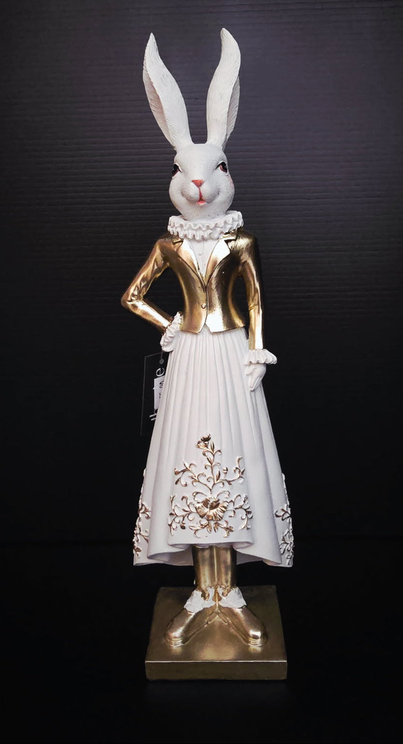 Statue of a rabbit in a gold and white outfit on a black background