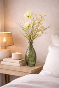 Cream and yellow faux wildflower bunch styled in a green glass vase on a timber bedside table with candle and lamp — bedroom home décor Australia Mistletoe Home