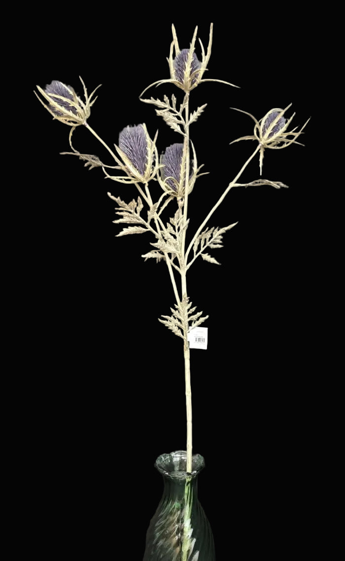 Single faux blue-purple thistle spray stem with multiple blooms and cream spiky bracts displayed in a green glass bottle on a black background — Mistletoe Home