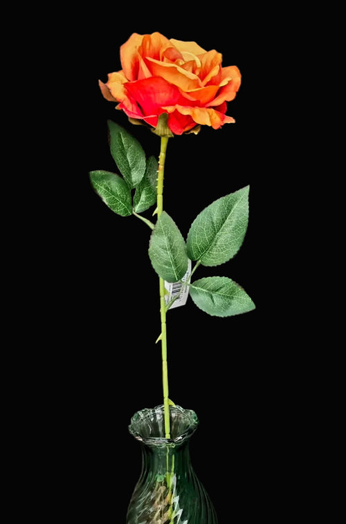 Single faux orange rose stem with orange-red ombré petals, thorned green stem and green leaves in a small glass vase on black background — 55cm tall — Mistletoe Home