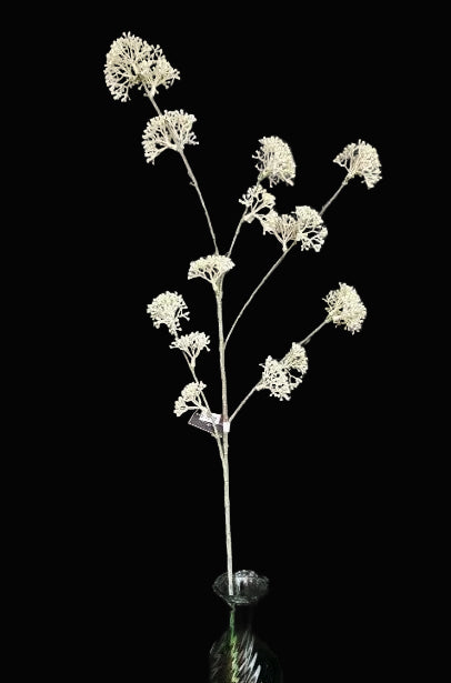 artificial plant in a green vase against a dark textured background