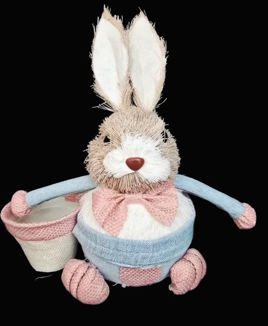 Stuffed bunny toy with a pink bow tie and blue scarf on a black background