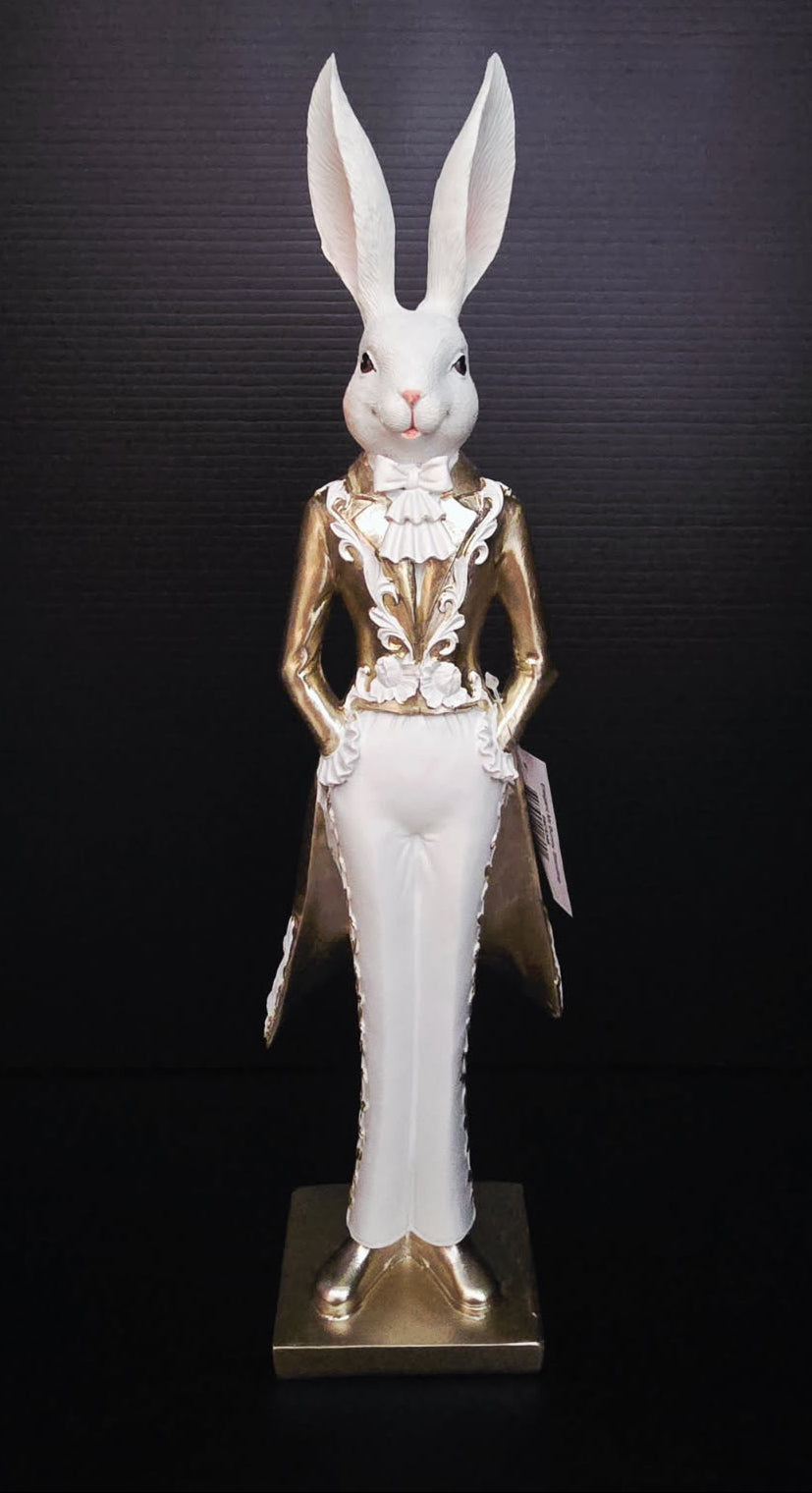 Statue of a rabbit in a formal outfit with gold and white elements on a dark background