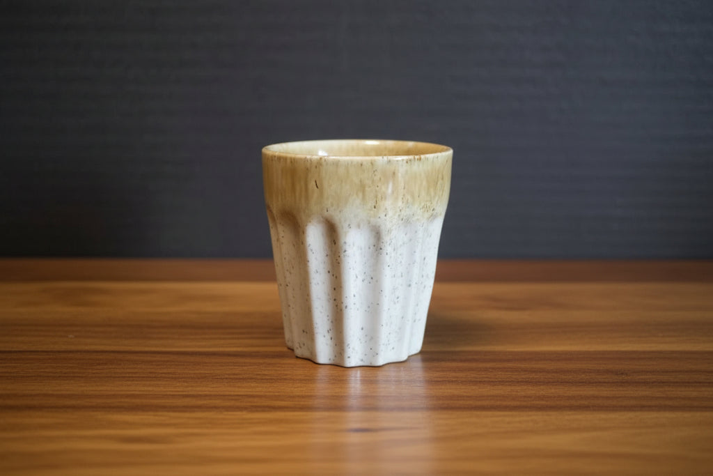 Ceramic espresso cup with textured design on a dark background