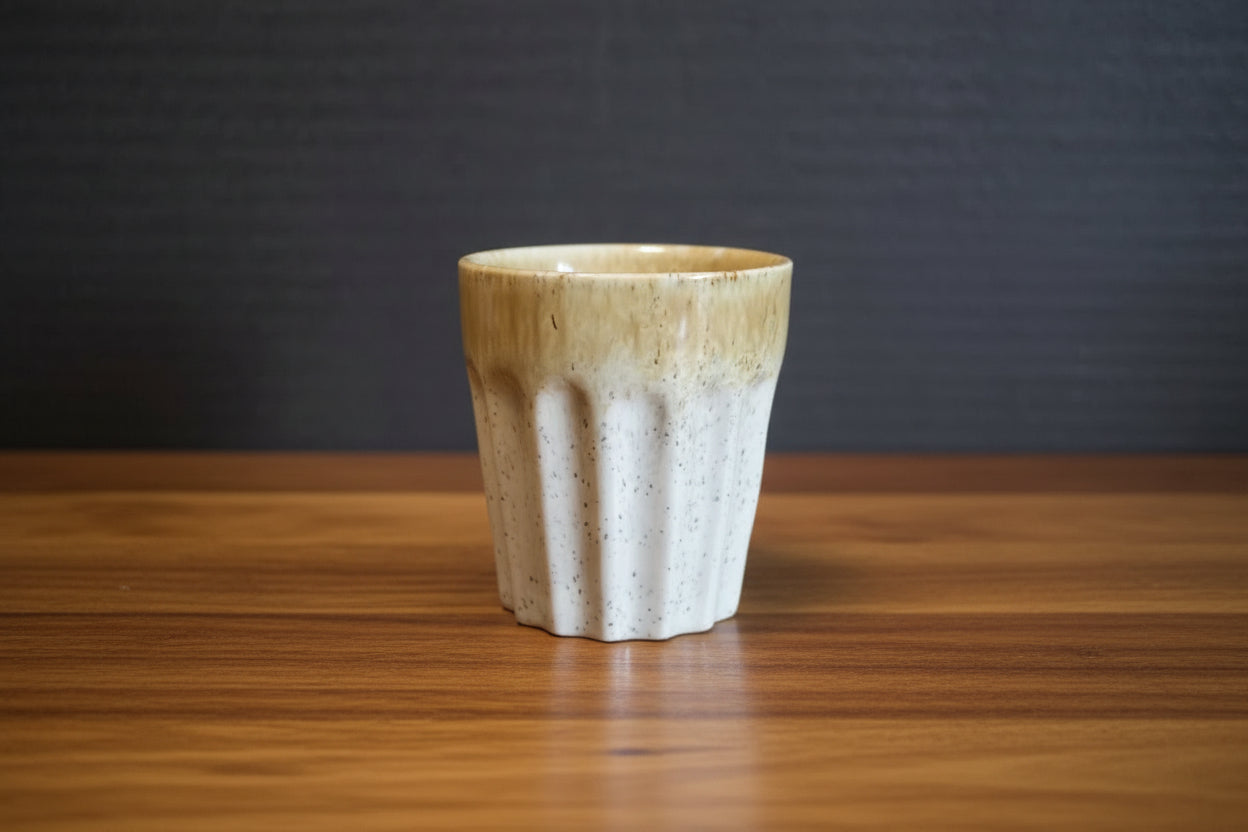 Ceramic espresso cup with textured design on a dark background