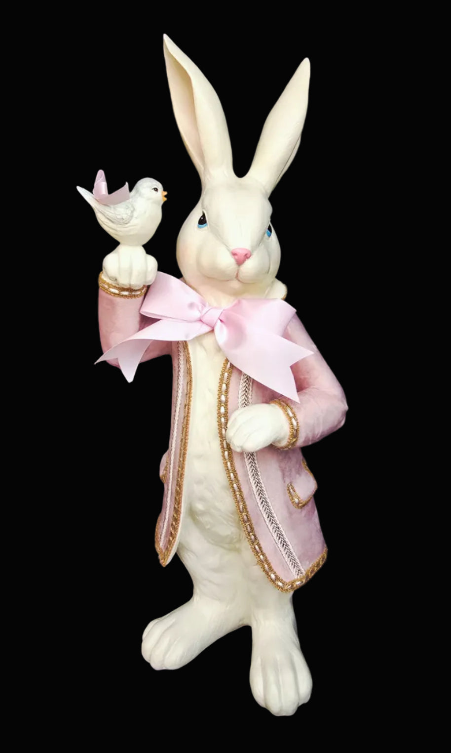 Decorative rabbit figurine with a pink bow and bird on a dark background