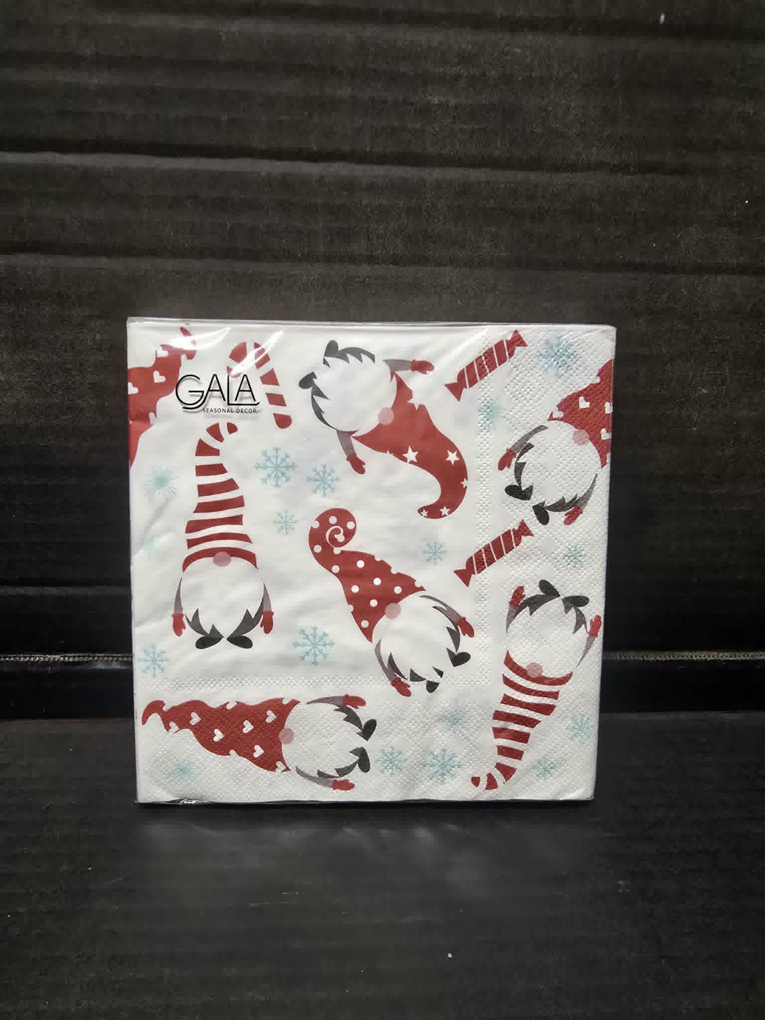 Pack of 20 white paper napkins with red Christmas gnome and blue snowflake print by Gala in clear packaging on dark background — Mistletoe Home