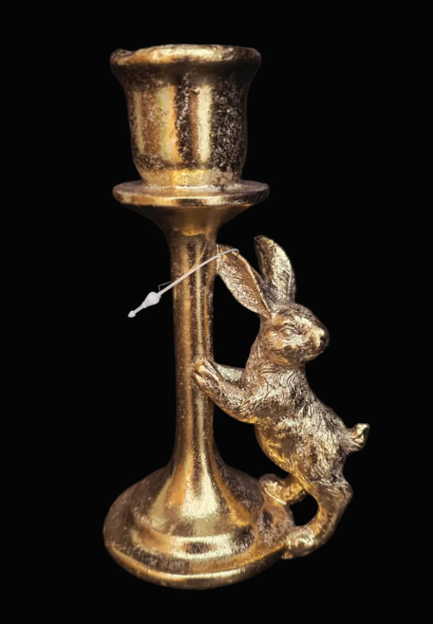 Gold candle holder with rabbit design on a black background