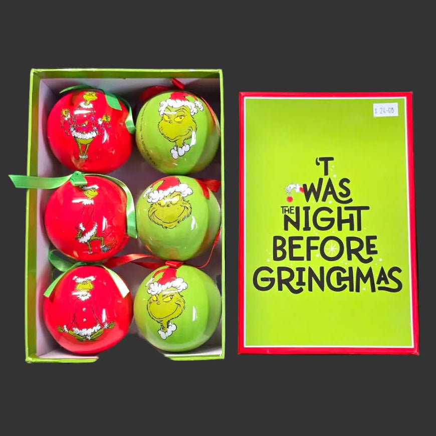 Box of Christmas ornaments with 'Grinch' design and a humorous tagline on a dark background.
