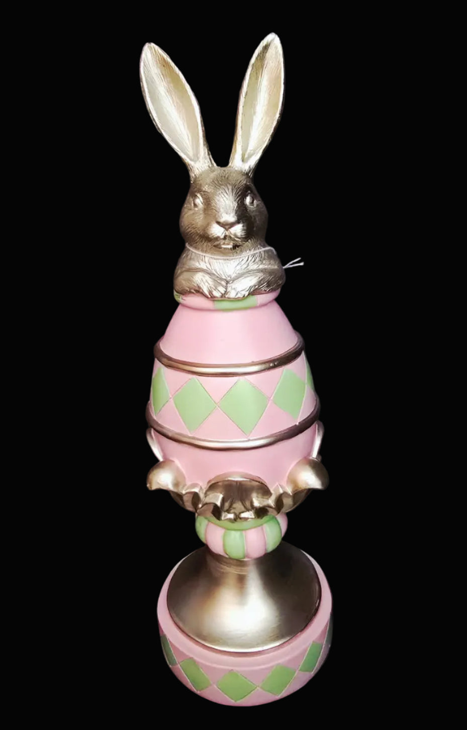 Decorative Easter bunny figurine with a pink and green egg on a black background