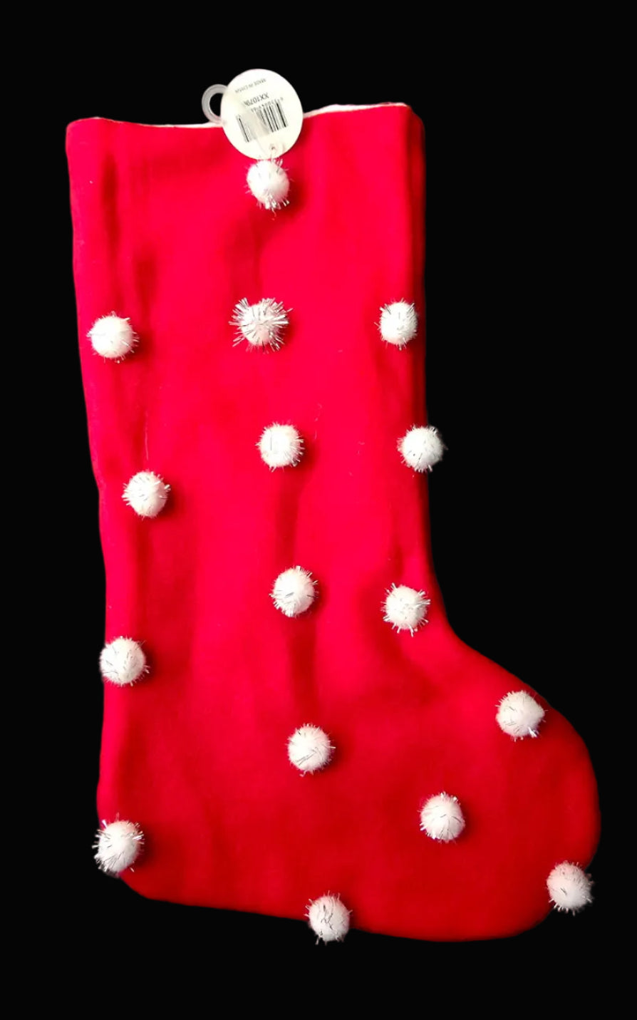 Red velvet Christmas stocking with white fluffy pom pom detail and hanging loop on black background — Mistletoe Home