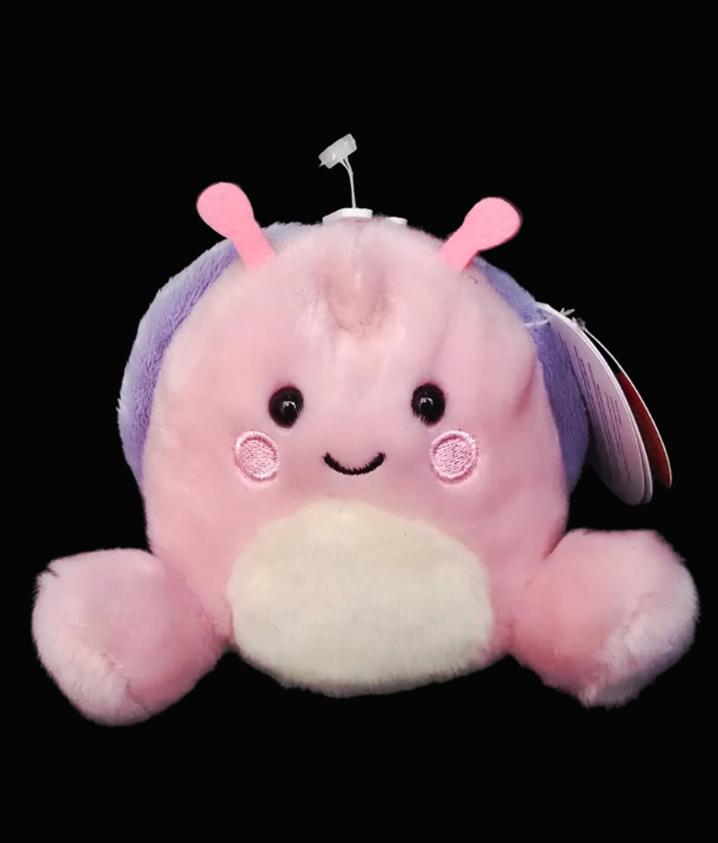 Plush toy with a purple shell and pink accents on a dark background