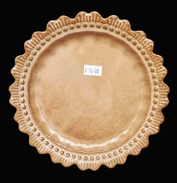 Decorative ceramic plate with textured rim on a black background