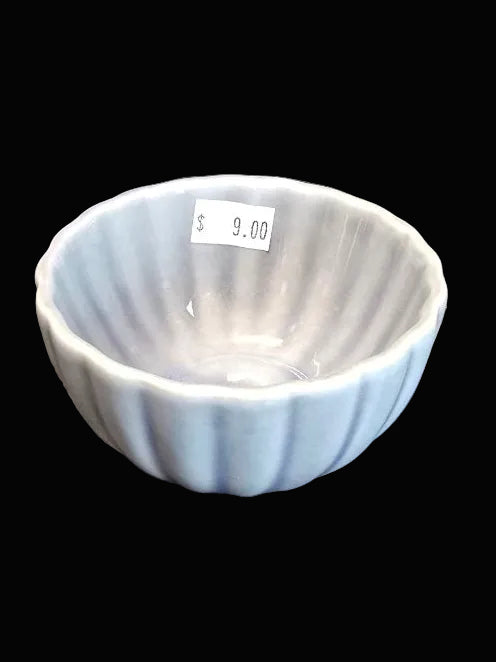 Small ceramic bowl with ribbed texture on a gray surface