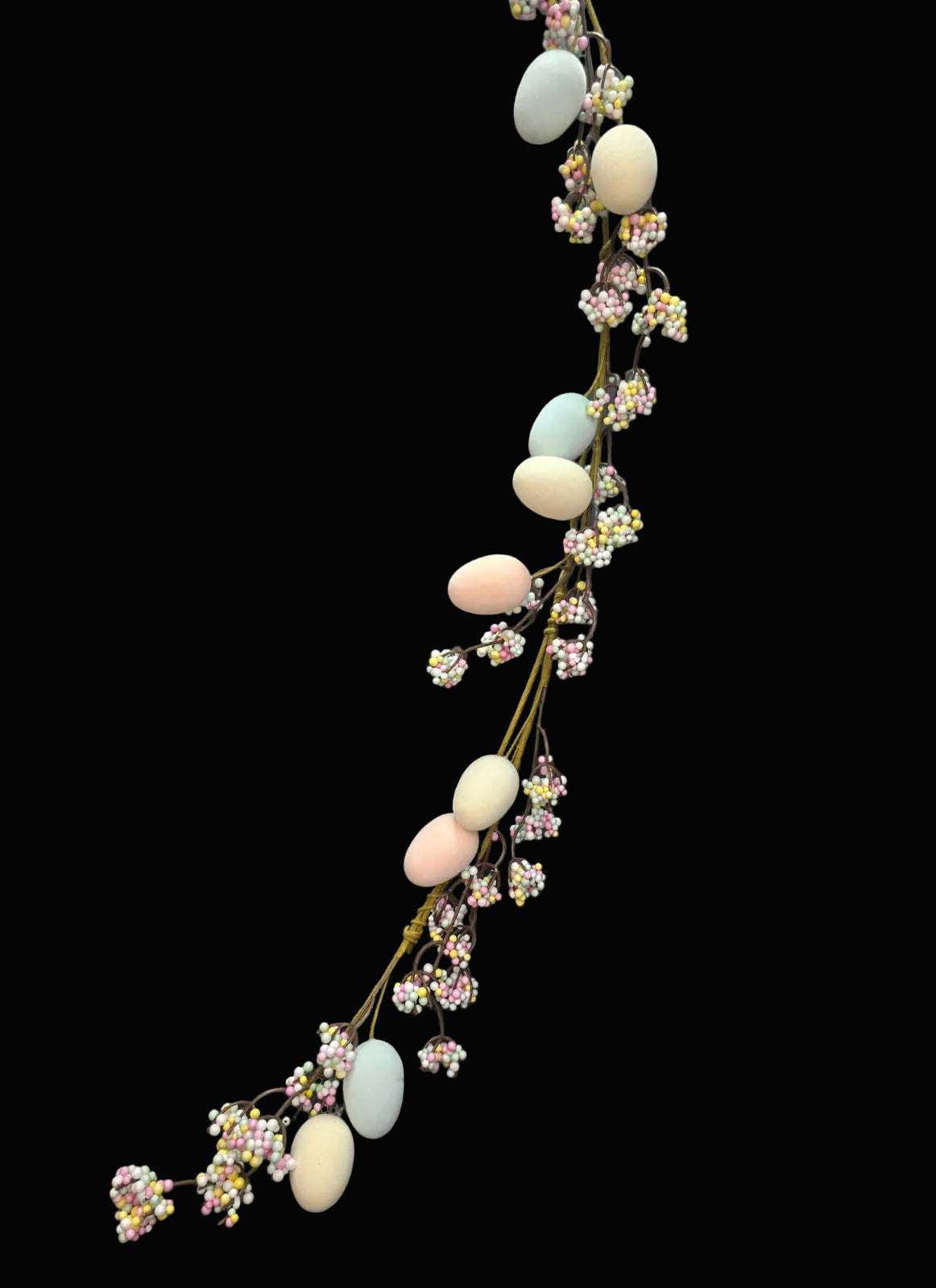Decorative branch with pastel-colored eggs and flowers on a black background